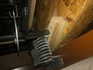 The intact support block under the left side of the La-Z-Boy rocker/recliner. No split wood. Foreground of the 2 springs is shown moderately stretched.