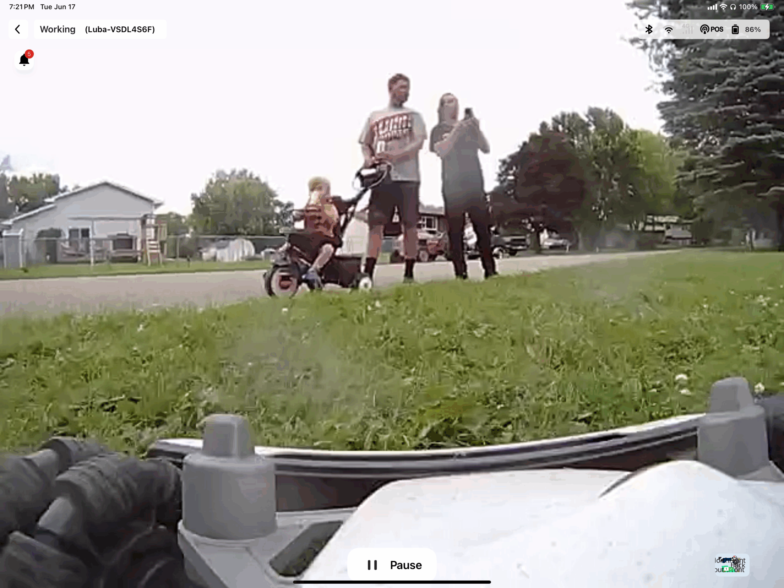 The "FPV" view from my Luba2 mower, showing it facing NE, and there's a young couple with a toddler in a stroller. They had stopped and watched the mower work for a few minutes, and now the mother is seen holding her phone up with the camera pointed at the side of my shed, where I have QR code signs which link to pages that give more information to those curious about either my #HamRadio antennas, or the #Mammotion #Luba2 mower.